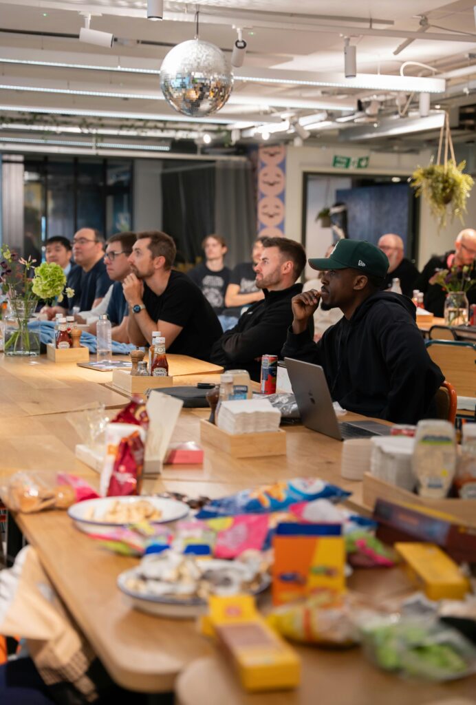 A casual office meeting in a modern setting with snacks and engaged participants.